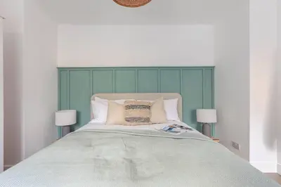 a bed with a green headboard in a bedroom at Stylish apartment with parking - Flat 2 Mill House in Penryn