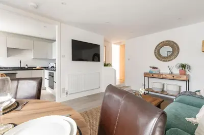 a living room with a dining table and a kitchen at Stylish apartment with parking - Flat 2 Mill House in Penryn