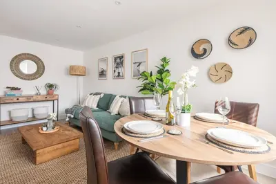 a living room with a table and a couch at Stylish apartment with parking - Flat 2 Mill House in Penryn