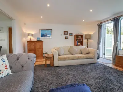 a living room with a couch and a window at Surf Break in Wadebridge