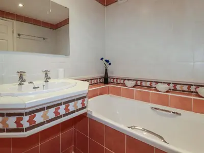 a bathroom with a tub and a sink at Surf Break in Wadebridge