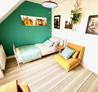 a green room with a bed and a chair at Seaview Surf Studios in Newquay