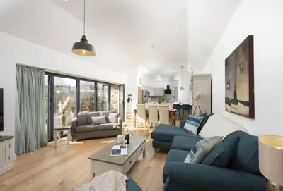 a living room with a blue couch and a table at Whitewood in Camborne