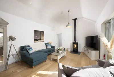 a living room with a blue couch and a tv at Whitewood in Camborne