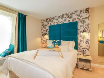 a bedroom with a large bed with a blue headboard at Kerensa in St Austell