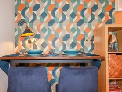 a table with blue dishes on it with a patterned wall at Kerensa in St Austell