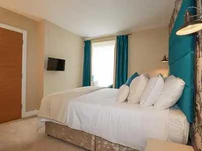 a bedroom with a large bed with white pillows at Kerensa in St Austell