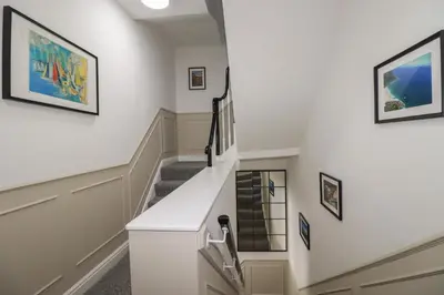 a staircase in a home with white walls at Kerensa in St Austell