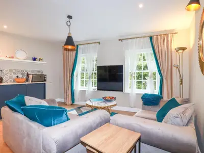 a living room with two couches and a table at Kerensa in St Austell
