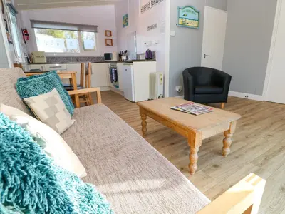 a living room with a couch and a table at Chalet 3 Wipeout in Hayle