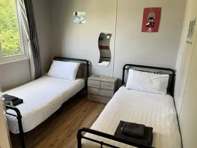 a room with two beds and a window at Chalet 3 Wipeout in Hayle