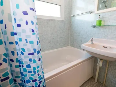 a bathroom with a white tub and a sink at Chalet 3 Wipeout in Hayle