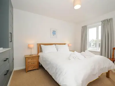 a bedroom with a white bed and a window at Slipway 14 in Wadebridge