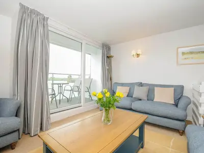 a living room with a couch and a table with flowers at Slipway 14 in Wadebridge
