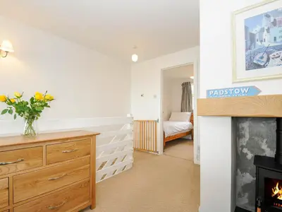 a living room with a fireplace and a bedroom at Slipway 14 in Wadebridge