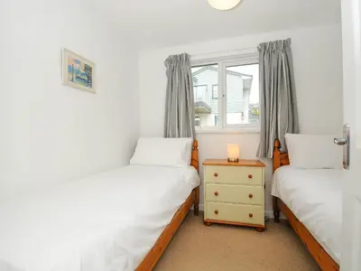 a bedroom with two twin beds and a window at Slipway 14 in Wadebridge
