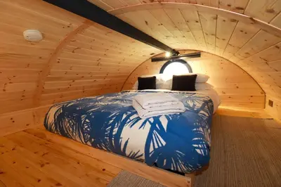 a bedroom with a bed in a wooden room at The Palm in Truro