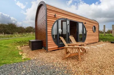 a wooden tiny house with a chair and a tv at The Palm in Truro