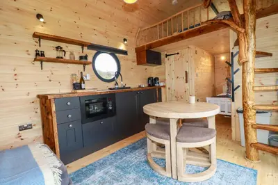a kitchen and dining room with a table in a cabin at The Palm in Truro