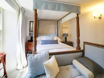a bedroom with a four poster bed and a couch at Tower Hill in Bodmin