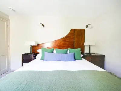 a bedroom with a bed with green and blue pillows at Tower Hill in Bodmin