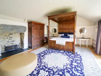 a bedroom with a large bed and a fireplace at Tower Hill in Bodmin