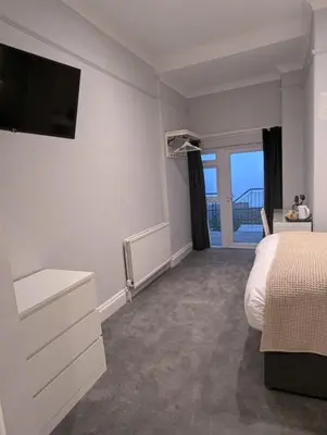 a bedroom with a bed and a tv on the wall at Fieldhead Hotel, Looe in Looe