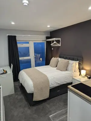a bedroom with a large bed and a window at Fieldhead Hotel, Looe in Looe