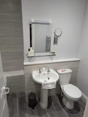 a white bathroom with a toilet and a sink at Fieldhead Hotel, Looe in Looe