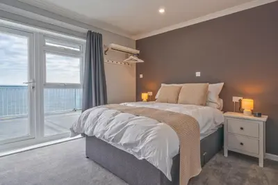a bedroom with a large bed and a large window at Fieldhead Hotel, Looe in Looe