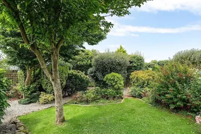 a garden with a green lawn and a tree at Peaceful Home Sea Views Private Parking in Treknow