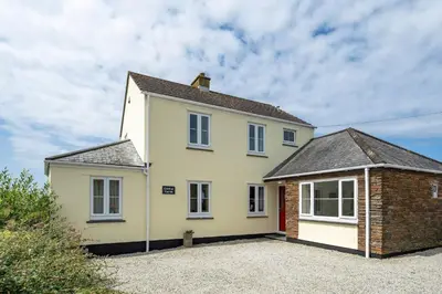 a white house with a brick at Peaceful Home Sea Views Private Parking in Treknow