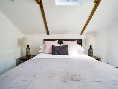 a bedroom with a large bed with pink pillows at Starfish Cottage in Charlestown
