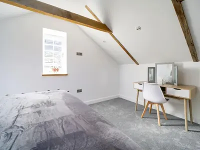 a bedroom with a bed and a desk at Starfish Cottage in Charlestown