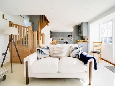 a white couch in a living room with a kitchen at Starfish Cottage in Charlestown
