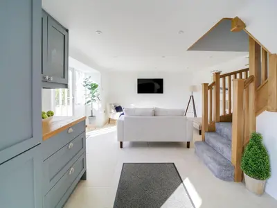 a living room with a staircase and a couch at Starfish Cottage in Charlestown