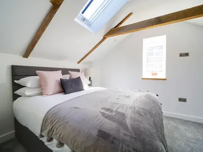 a bedroom with a large bed with pink pillows at Starfish Cottage in Charlestown