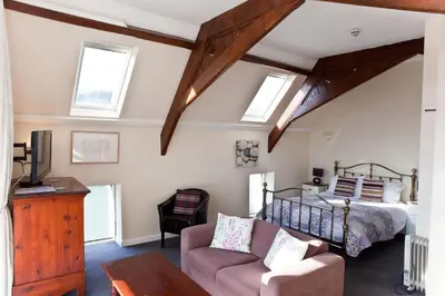 a bedroom with a bed and a couch at The Old School Hotel in Port Isaac