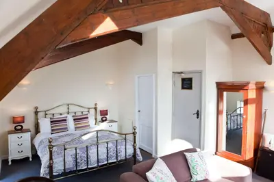 a bedroom with a bed with a wooden frame at The Old School Hotel in Port Isaac
