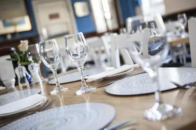 a table with wine glasses and napkins on it at The Old School Hotel in Port Isaac