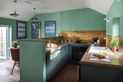 a kitchen with blue and green walls and a counter at Topsy Turvy and Hillside Spa at Tregoose Old Mill in Newquay