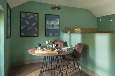 a dining room with a table and two chairs at Topsy Turvy and Hillside Spa at Tregoose Old Mill in Newquay