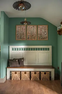 a bench in a room with a green wall at Topsy Turvy and Hillside Spa at Tregoose Old Mill in Newquay