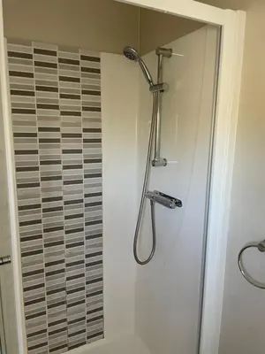 a shower with a shower head in a bathroom at Rubys Retreat - 6 Berth Caravan in Newquay, Cornwall in Newquay