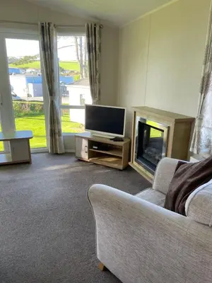 a living room with a couch and a television at Rubys Retreat - 6 Berth Caravan in Newquay, Cornwall in Newquay