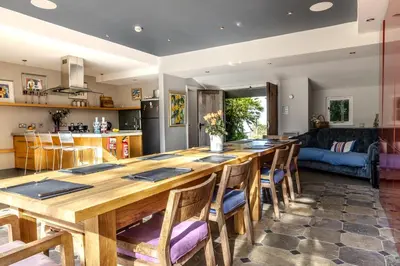 a kitchen and living room with a large wooden table at Trevornick Farm House in Newquay