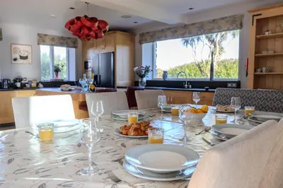 a dining room table with plates and wine glasses at Trevornick Farm House in Newquay