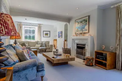 a living room with a couch and a fireplace at Trevornick Farm House in Newquay