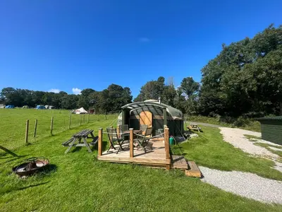 a tent and picnic table in a field at Yurt in Hayle