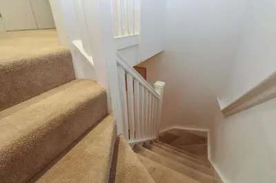 a staircase in a home with white walls and brown carpet at Una, Lodge 73 in St Ives